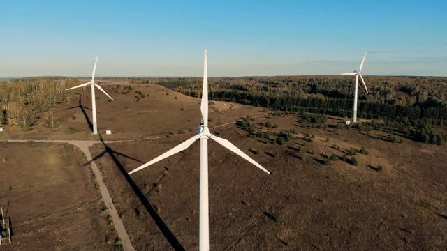 Metal wind towers on a field. Renewable energy concept.