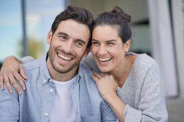  Portrait of very attractive couple smiling outside modern house