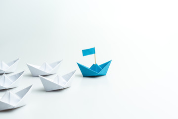 Leadership concept, blue paper ship leading among white on white background. - obrazy, fototapety, plakaty