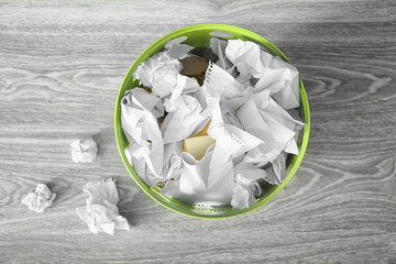 Rubbish bin with crumpled paper on floor. Mistake concept