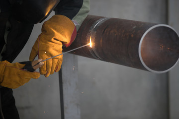 Worker welding metal piping using tig welder