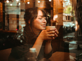 Asian woman drinking coffee in  coffee shop cafe