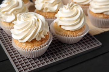 Delicious cupcakes on dark wooden table