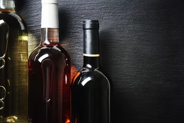 Rolgordijnen Bottles with different kinds of wine on dark background © Pixel-Shot