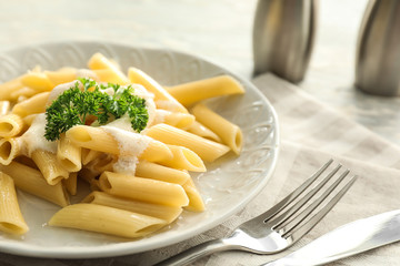 Tasty penne pasta with cream sauce on plate