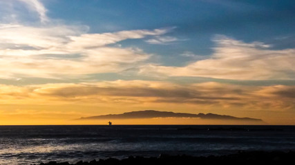 Cruise boat with tourists ship and move on the water of the ocean traveling from islands during a golden beautiful sunset