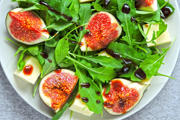 Bright healthy arugula fig salad. Fitness food. Colorful, healthy foods in flatlay style