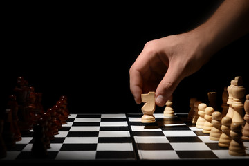 Man playing chess on dark background