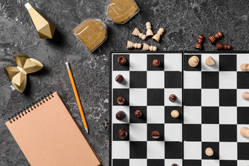 Composition with chess pieces and game board on grey background