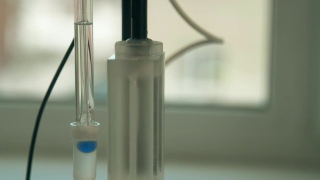Electrode from pH meter is lowered into the liquid and measures level of acidity. Glass electrode and conductometric cell.