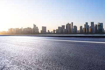 empty asphalt road with city skyline