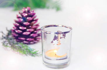  New Year's multicolored decorative shiny cones with a candlestick against the green branches of the Christmas tree