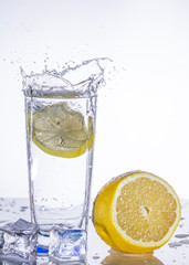 Fototapeta na wymiar A glass of lemonade on a light background with splashing water