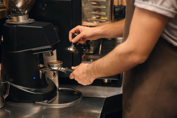 Barista preparing fresh aromatic coffee in cafe