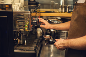 Barista preparing fresh aromatic coffee in cafe