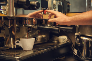 Barista preparing fresh aromatic coffee in cafe