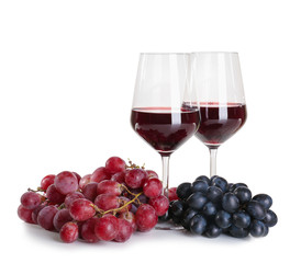 Glasses of red wine with ripe grapes on white background