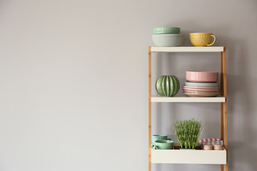 Set of clean tableware on shelving unit