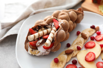 Delicious bubble waffle with berries and fruits on plate
