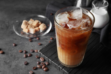 Glass of cold coffee on dark table