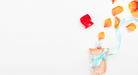 Flat lay. Top view. Minimalist fashion and beauty photo. Delicate roses and perfume bottle on a white background