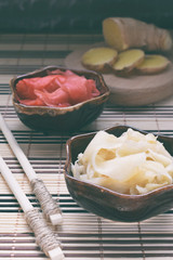Pickled ginger slices and wooden chopsticks. Ingredient for sushi. Healthy food. Traditional Japanese condiment