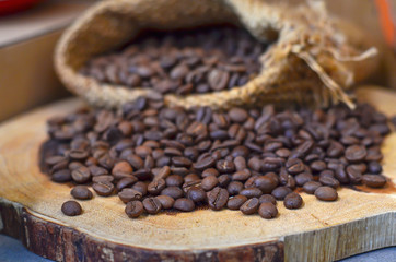 A sack of roasted coffee beans on wooden