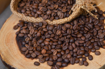 A sack of roasted coffee beans on wooden