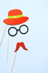 Colorful props for party. Carnival accessories set. Paper glasses, hat, lips, moustaches, tie on wooden sticks.