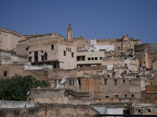 Fototapeta na wymiar Panorama of the old town in Fez, Morocco, roofs of an with brown houses and satellite antennas in an Arabic medina 