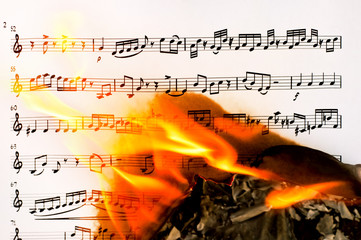  Burning sheet of paper with musical notes closeup
