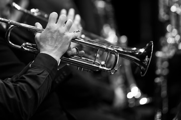 Trumpet in the hands of a musician closeup in black and white tones