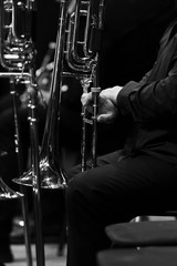 Fototapeta premium Trombone in the hands of a musician in an orchestra in black and white