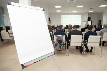 Board on background of audience in conference room. Business concept