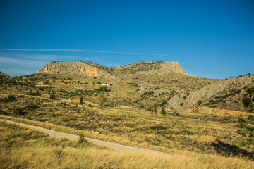 small country side curved car road in dry warm and hot mountain valley nature scenery landscape environment  