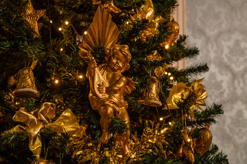 Weihnachtsbaum mit goldenen Schleifen, Glöckchen und einem Engel