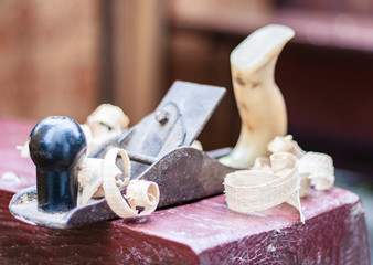 Joinery – old wooden plane and chips in a workshop of the carpenter