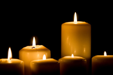 Burning candle in darkness