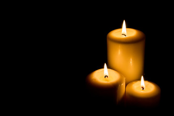 Burning candle in darkness