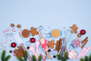 Baking Christmas cookies card. Christmas spices, cookie cutters, ingredients for christmas baking and kitchen utensils gingerbread cookies on blue pastel background