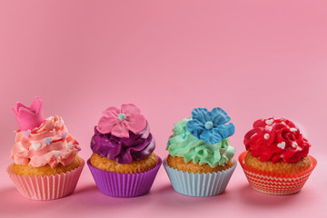 Tasty cupcakes on color background