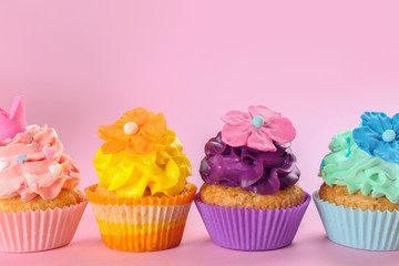 Tasty cupcakes on color background