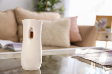 Automatic air freshener on glass table indoors