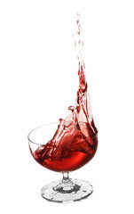 Glass with red splashing wine on white background
