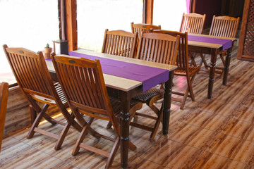 The simple interior of the cafe with wooden furniture and purple trim.
