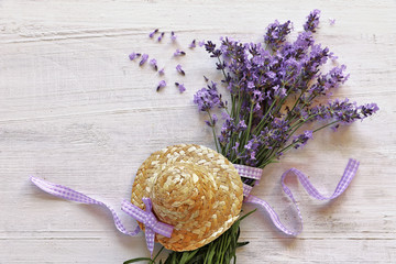 Lavender flowers with straw hat  on wooden background 