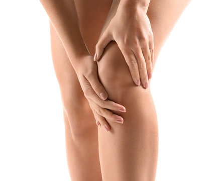 Woman suffering from pain in knee on white background