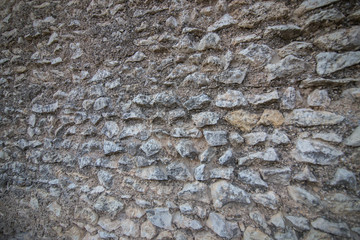 Texture of an ancient stone on a wall covered with moss