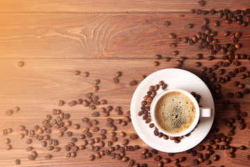 Cup of aromatic coffee and coffee beans on wooden background. Top view. Coffee drink