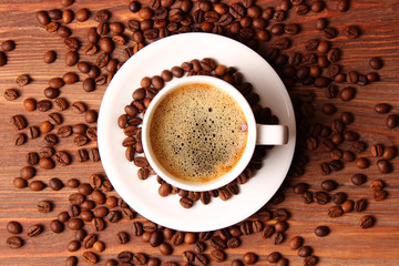Cup of aromatic coffee and coffee beans on wooden background. Top view. Coffee drink